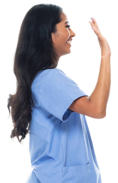 One person of aged 20-29 years old who is beautiful with long hair generation z female standing in front of white background who is laughing and greeting and showing hand raised