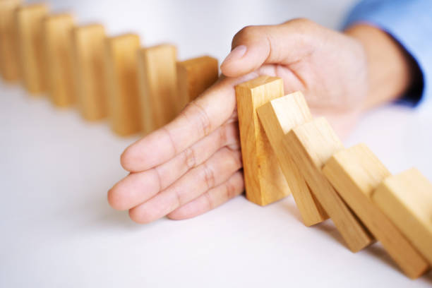 istock Female hand stopping wooden brick block,  risk and security solution concept. 1210151301