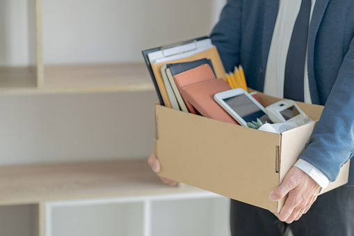 Un hombre de negocios estresante empacando una caja para dejar un trabajo. photo