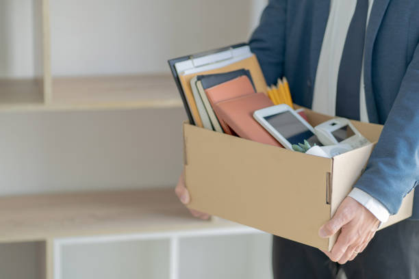 un hombre de negocios estresante empacando una caja para dejar un trabajo. - unemployment fotografías e imágenes de stock