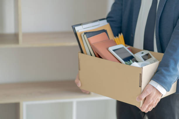 stressful businessman packing a box for quit a job. - unemployment imagens e fotografias de stock