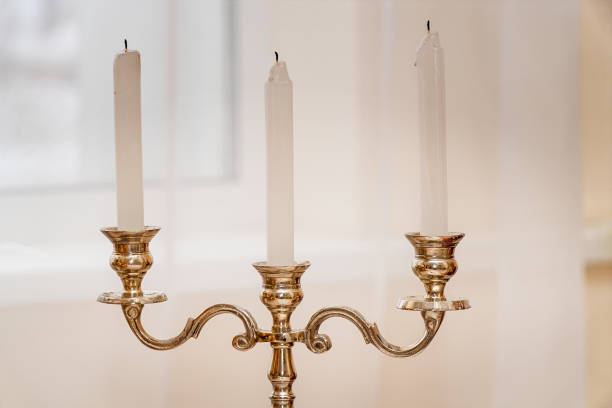 istock Antique gold candlestick with three candles on light background 1210156921