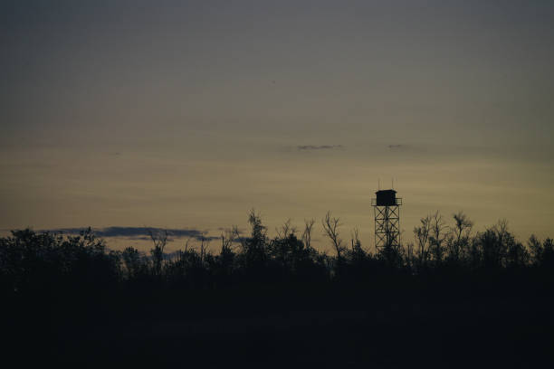 The silhouette of a Guard tower against the evening sky