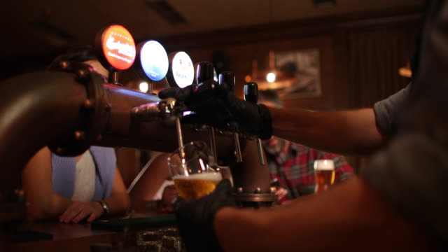 Barman pouring beer in pub