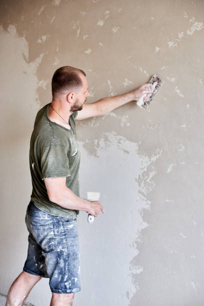 istock Male plastering wall with putty-knife, close up. Fixing wall surface and preparation for painting. 1210160551