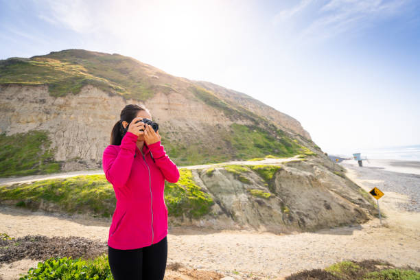 A Women Hiker Taking Photos Of The Ocean A Women Hiker Taking Photos of Torrey Pines and the ocean. torrey pines state reserve stock pictures, royalty-free photos & images