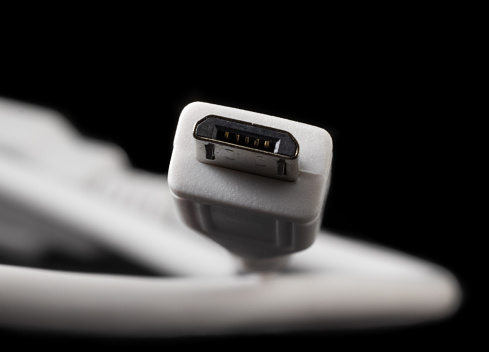 Micro USB type B or USB-B plug and white cable close-up.