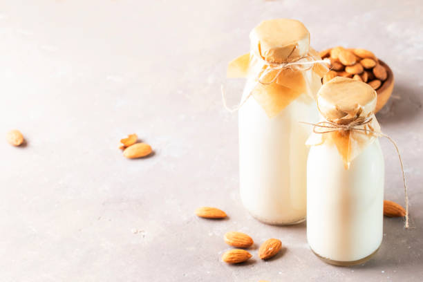 istock Almond milk with almond on brown table 1210162100
