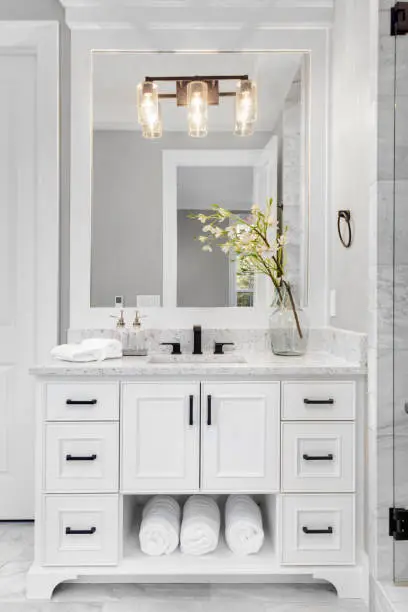 Photo of Beautiful bathroom interior in new luxury home with vanity, mirror, and cabinets