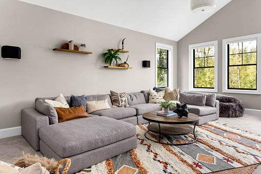 Hermoso interior de la sala de estar con alfombra de área colorida, sofá grande, y abundante luz natural photo