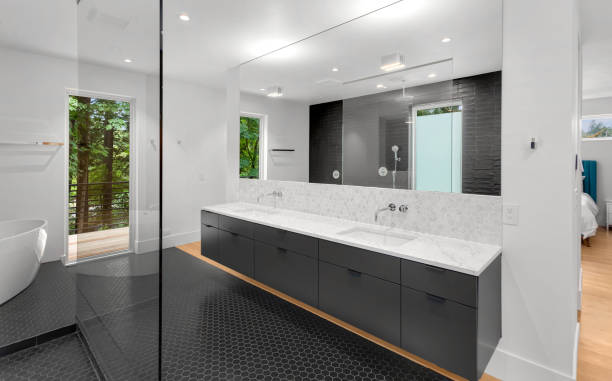 Beautiful modern bathroom interior in new luxury home with double vanity, mirror, and cabinets