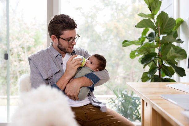 istock Smiling dad gives baby a bottle 1210165435