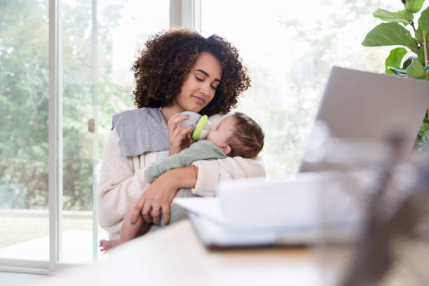istock Working mom gives her infant a bottle 1210165436