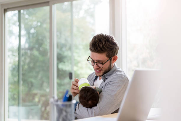 istock Smiling dad gives his baby a bottle 1210165438