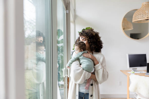 istock Mom and baby look through window 1210165441