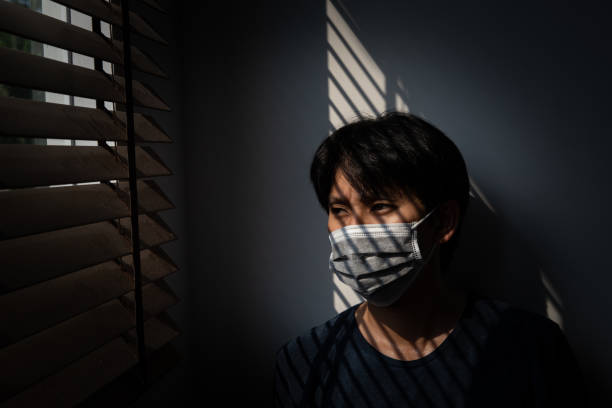 Quarantine of risky people to prevent COVID-19 spreading, Man wearing mask and looking out on the window at home, Corona virus. COVID-19 and epidemic virus symptoms and protection. Coronavirus and Air pollution pm2.5 concept. cuarentena de personas de riesgo para evitar que covid-19 se propague, hombre usando máscara y mirando a la ventana en casa, virus corona. coronavirus de wuhan y síntomas y protección del virus epidémico. coronavirus y contaminación atmosférica conce