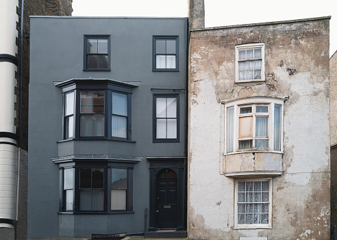 A renovated three floor town house  alongside a similar building before restoration.