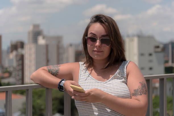 istock Confident young woman with raised eyebrow on rooftop 1210167161