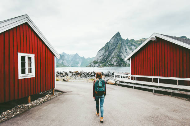 Tourist woman walking sightseeing Lofoten islands in Norway Travel lifestyle concept adventure outdoor summer vacations girl backpacker Tourist woman walking sightseeing Lofoten islands in Norway Travel lifestyle concept adventure outdoor summer vacations girl backpacker reine lofoten stock pictures, royalty-free photos & images