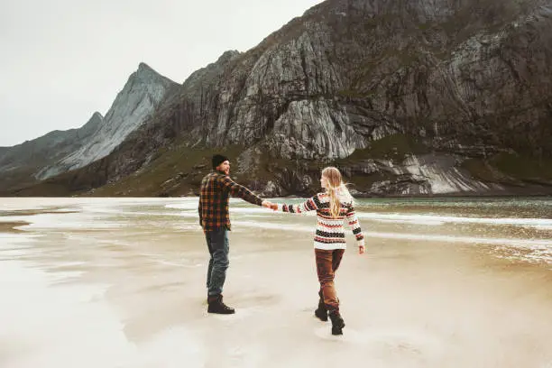 Photo of Couple walking together on beach holding hands Man and Woman together traveling Lifestyle concept romantic vacations at northern sea
