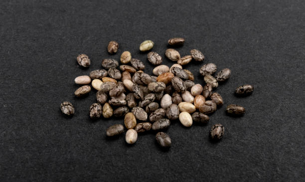 istock Small pile of chia seeds on black background 1210170320