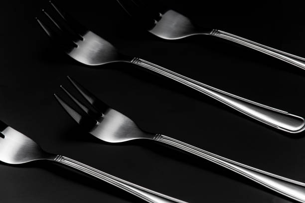 istock Silver Forks in Row on Dark Background. Low Kay Noir Image. Still Life Pattern Background 1210171387