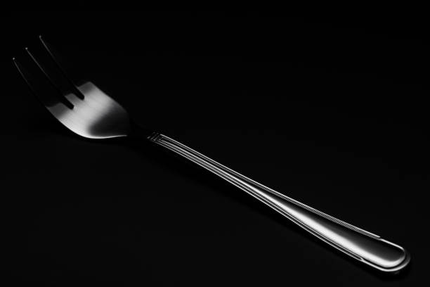 istock One Silver or Stainless Steel Fork. Close Up Detail view. Dark Background. Low Key Image 1210171403