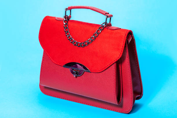 istock women's handbag in red leather and suede, side view 3/4 object on a blue background. 1210174022