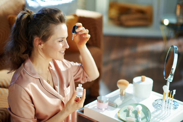 istock woman using cosmetic elixir at modern home in sunny winter day 1210175094