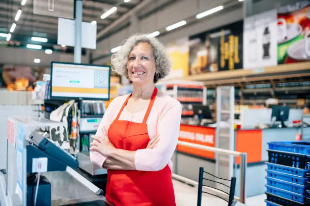 Portrait of Senior woman working at supermarket checkout