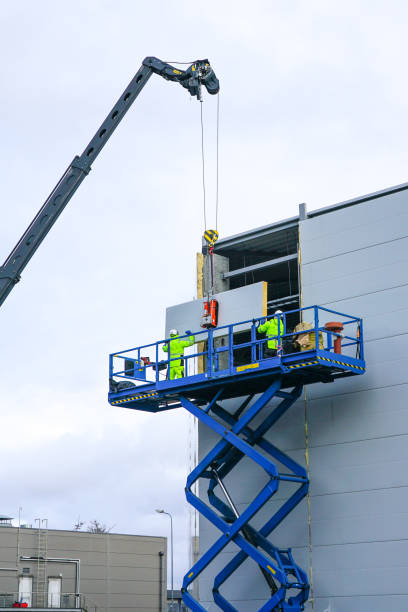 sandwich panels wall mounting using crane and scissor lift steel sandwich panels wall mounting using crane and scissor lift sandwich panel photos stock pictures, royalty-free photos & images