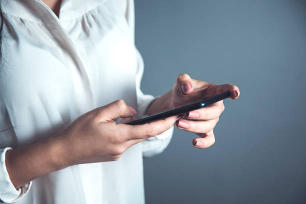 business woman hand smart phone on gray background
