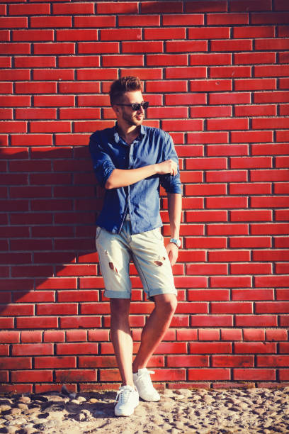 istock Man wearing a shirt and torn shorts 1210178067