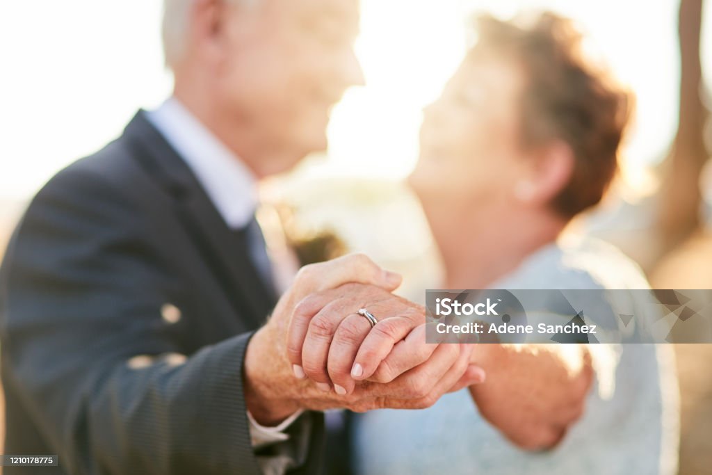 We're dancing off to our happily ever after Cropped shot of an unrecognizable senior couple dancing and enjoying themselves outdoors on their wedding day Wedding Stock Photo