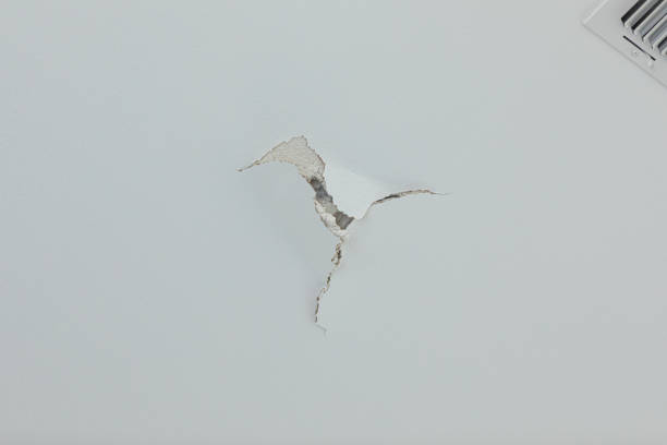 istock large crack puncture hole in the ceiling wall with a fan vent near it 1210180030