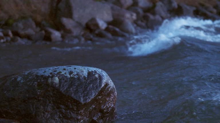 Wave crashing in to a rock and spraying water