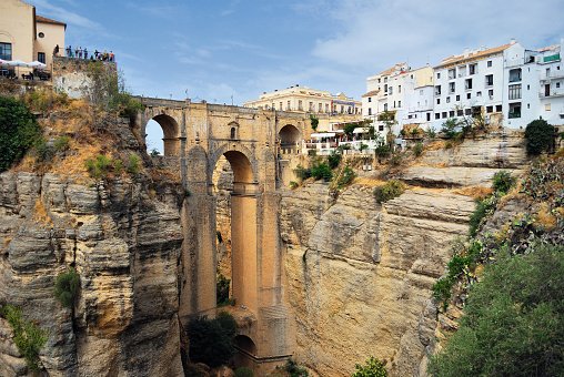 View of Alcantara bridge over the river Tagus with the town Toledo on the other side of the bridge. The stone arch bridge was built over the Tagus River between 104 and 106 AD by an order of the Roman emperor Trajan.