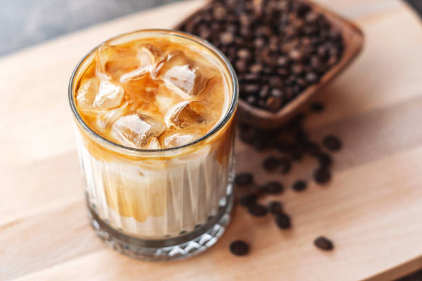 istock Iced latte coffee with milk and ice cubes served on wood 1210180577