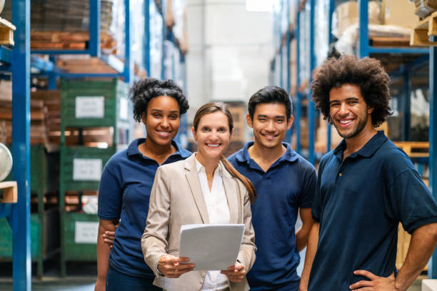 Warehouse Manager With Workers In Factory Stock Photo - Download Image Now  - Warehouse Worker, Warehouse, Smiling - iStock