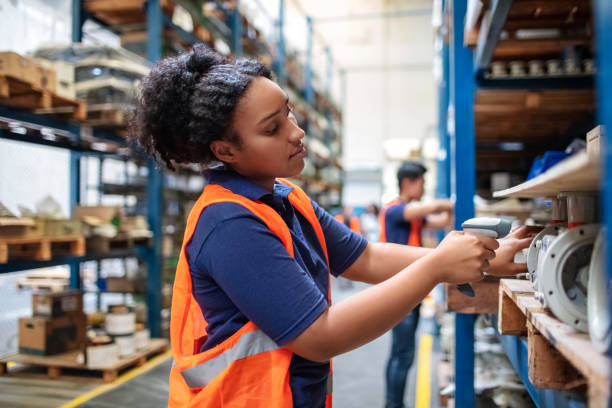 Warehouse worker checking cargo on shelves with scanner Warehouse worker checking cargo on shelves with scanner. Female worker in uniform scanning boxes in shelves. hardware store photos stock pictures, royalty-free photos & images