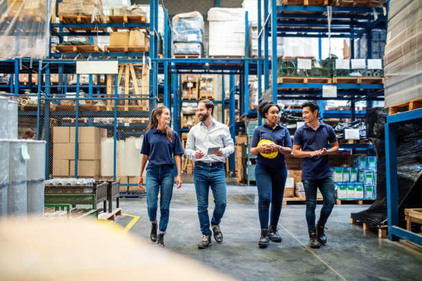 istock Group of warehouse employees walking by storage racks 1210182406