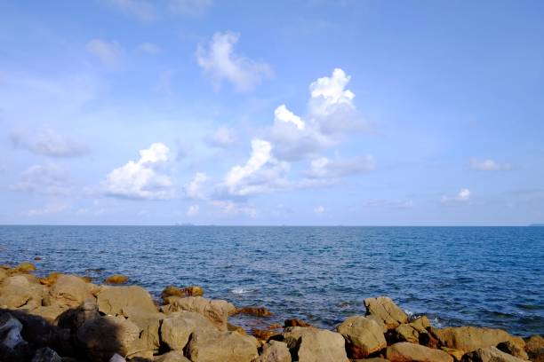 istock A horizontal line of deep blue sea with water waves and blue sky white fluffy clouds 1210182545
