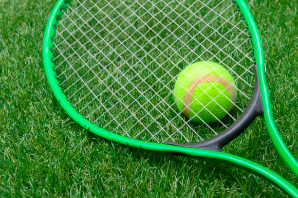 istock Tennis racket and ball on green grass 1210182738
