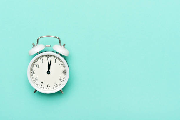 istock Vintage alarm clock isolated on pastel mint background 1210183373