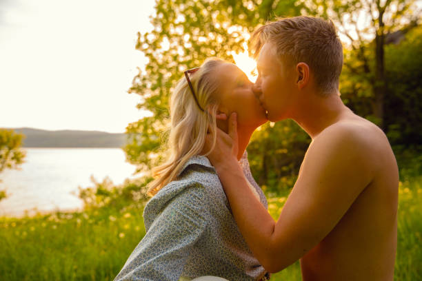 istock Young Shirtless Man Kissing Girlfriend During Sunset 1210183719