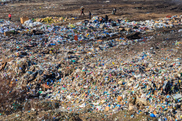 Poor people collecting garbage at city garbage dump. Pile of plastic trash, food waste on landfill Horishni Plavni, Ukraine - February 29, 2020: Poor people collecting garbage at city garbage dump. Pile of plastic trash, food waste on landfill. Concept of poverty and environmental pollution rag picker stock pictures, royalty-free photos & images