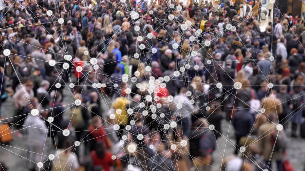 Coronavirus particles spreading in a crowd of people. Visualization of coronavirus multiplying with a background of people at a train station concourse. spreading photos stock pictures, royalty-free photos & images