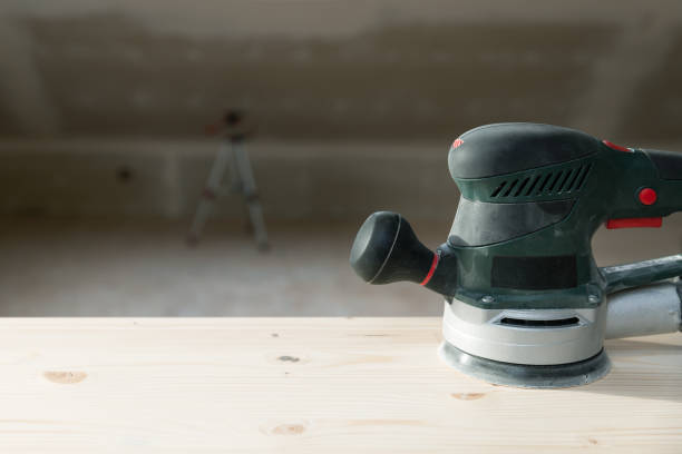 istock Worker grinds the wood with orbital sander machine in a natural light 1210185085