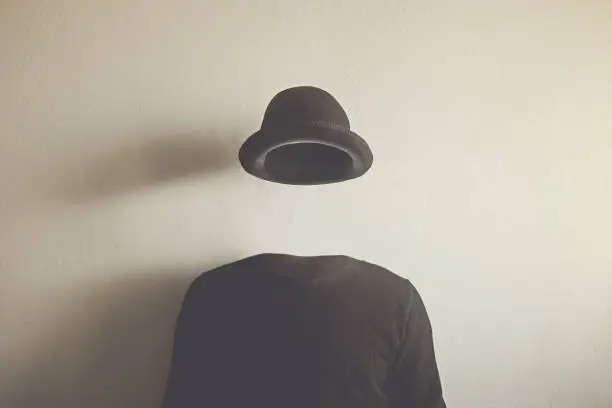 Photo of invisible man wearing black bowler, surreal concept of absence of identity