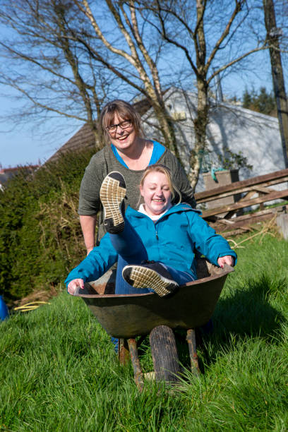 istock mother pushing daughter in wheelbarrow 1210188089